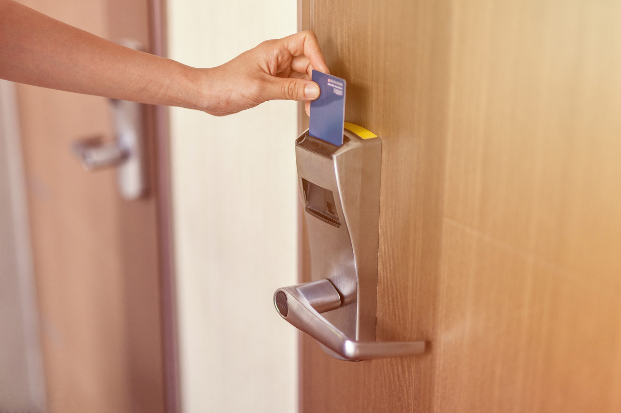 female hand insert room card key to open hotel room door